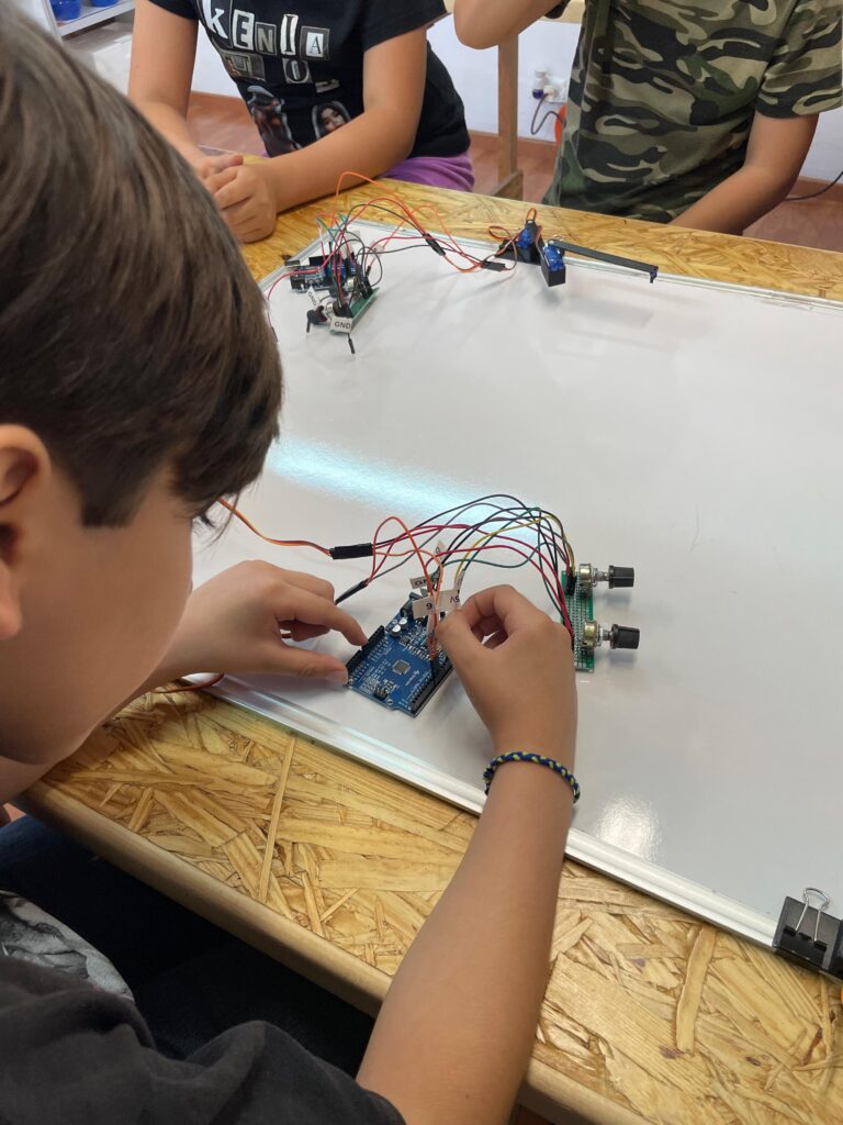 Niño jugando con un Robot Dibujante parte de los materiales educativos de Dimex.