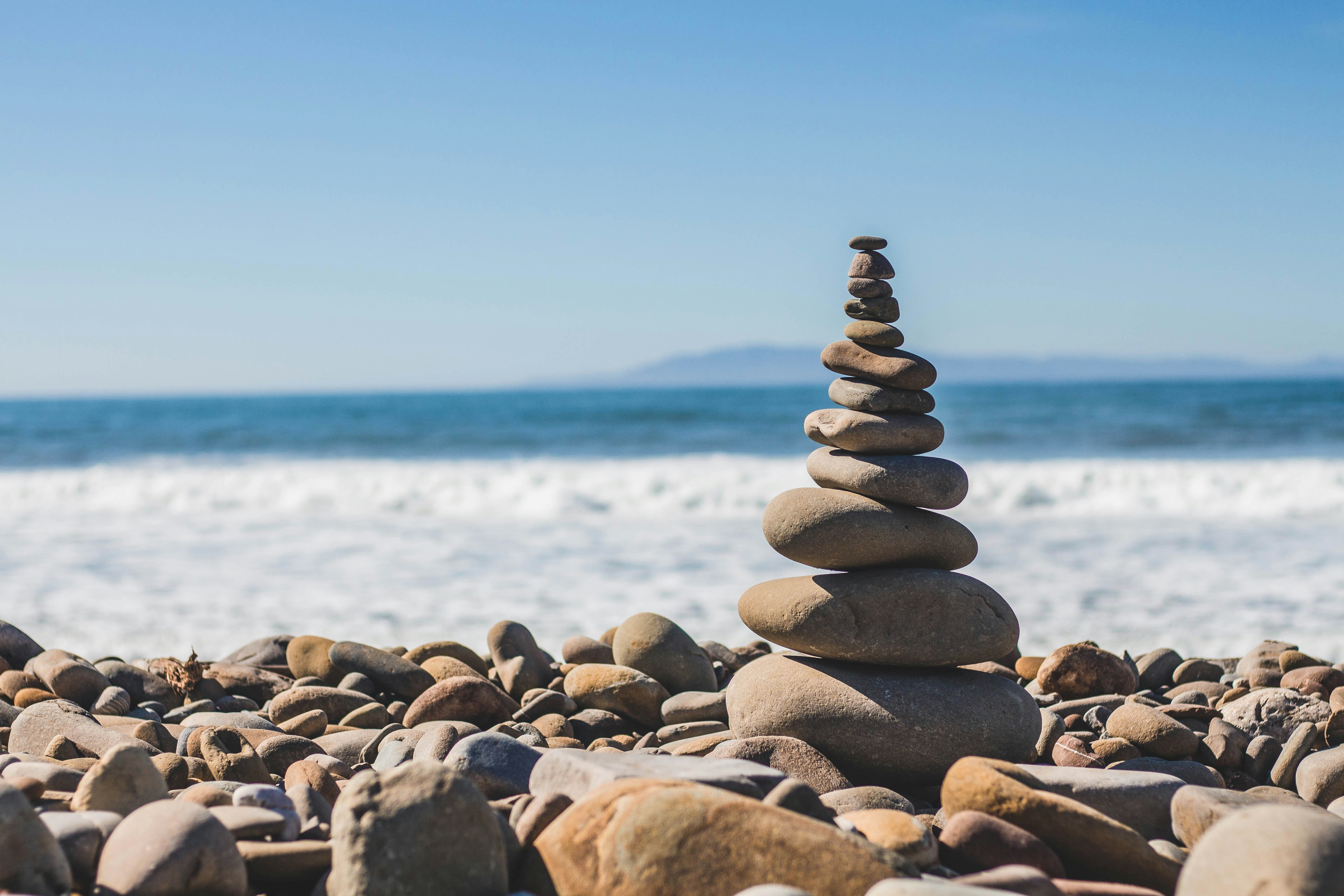 Piedras apiladas frente al mar enfatizando las características balanceadas en la búsqueda de que es información.